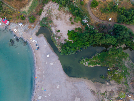 Aerial view of Arapya beach where a river flows into the Black Sea featuring sandy shores lush green vegetation and a dirt road in Burgas Bulgaria. Aerial view of Arapya beach where a river flows into the Black Sea featuring sandy shores lush green vegetation and a dirt road in Burgas Bulgaria.