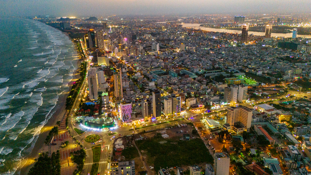 Aerial view of Da Nang city at night featuring illuminated skyscrapers coastal roads and the beach stretching along the coastline in Da Nang Vietnam. Aerial view of Da Nang city at night featuring illuminated skyscrapers coastal roads and the beach stretching along the coastline in Da Nang Vietnam.