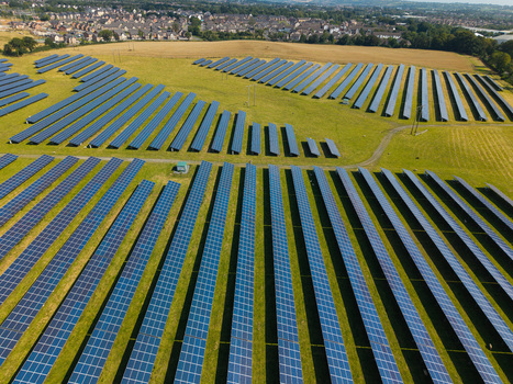 Aerial view of Lisburn Solar Farm with rows of photovoltaic panels arranged in a green field near residential houses in Lisburn Northern Ireland United Kingdom. Aerial view of Lisburn Solar Farm with rows of photovoltaic panels arranged in a green field near residential houses in Lisburn Northern Ireland United Kingdom.
