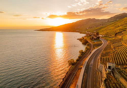 Aerial view of the Lavaux vineyards at sunset with a coastal road and railway tracks running along Lake Geneva in Bourg en Lavaux Vaud Switzerland. Aerial view of the Lavaux vineyards at sunset with a coastal road and railway tracks running along Lake Geneva in Bourg en Lavaux Vaud Switzerland.