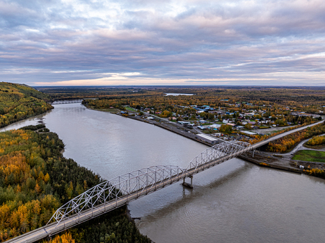 Aerial view of the Nenana Bridge spanning the Tanana River surrounded by vibrant autumn foliage under a cloudy sky in Nenana Alaska United States. Aerial view of the Nenana Bridge spanning the Tanana River surrounded by vibrant autumn foliage under a cloudy sky in Nenana Alaska United States.