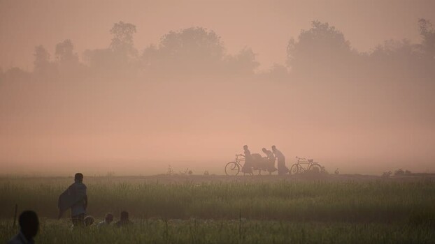 View of people with bicycles in a misty rural field Bangladesh. View of people with bicycles in a misty rural field Bangladesh.