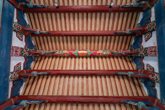 View of the intricate traditional wooden ceiling structure with red beams and ornate painted brackets inside Chihkan Tower in Chihkan Village Tainan City Taiwan. View of the intricate traditional wooden ceiling structure with red beams and ornate painted brackets inside Chihkan Tower in Chihkan Village Tainan City Taiwan.