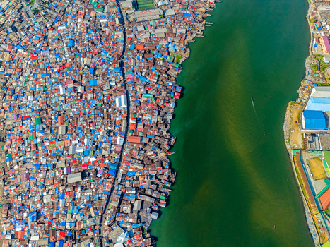 Aerial view of densely packed colorful rooftops of an informal settlement along a dark green river in Monrovia Montserrado Liberia. Aerial view of densely packed colorful rooftops of an informal settlement along a dark green river in Monrovia Montserrado Liberia.