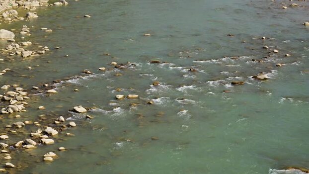 View of a flowing river with rocky banks Nepal.