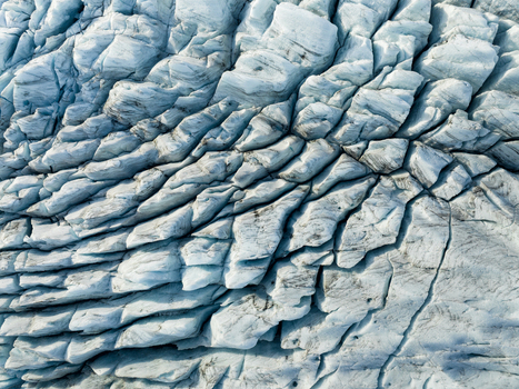 Aerial view of the glacier s icy expanse carved by time and weather reveals a landscape of fractured beauty and stark contrast Fjallsarlon Sveitarfélagið Hornafjörður Iceland. Aerial view of the glacier s icy expanse carved by time and weather reveals a landscape of fractured beauty and stark contrast Fjallsarlon Sveitarfélagið Hornafjörður Iceland.
