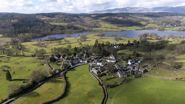 Aerial view of a charming village nestled in the verdant landscape with Windermere lake shimmering in the distance England United Kingdom. Aerial view of a charming village nestled in the verdant landscape with Windermere lake shimmering in the distance England United Kingdom.