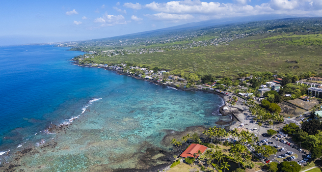 Aerial view of Kahalu u Beach Park featuring turquoise waters vibrant coral reefs and a red roofed pavilion along the volcanic coastline in Kailua Kona Hawaii United States. Aerial view of Kahalu u Beach Park featuring turquoise waters vibrant coral reefs and a red roofed pavilion along the volcanic coastline in Kailua Kona Hawaii United States.
