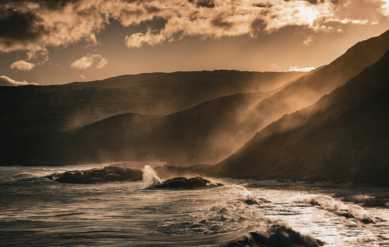 View of Sandpatch coastline with crashing waves against rocky cliffs under dramatic golden hour light in Sandpatch Western Australia Australia. View of Sandpatch coastline with crashing waves against rocky cliffs under dramatic golden hour light in Sandpatch Western Australia Australia.