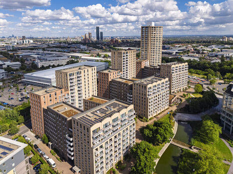 Aerial view of modern apartment buildings with solar panels on rooftops surrounded by greenery and a canal in London England United Kingdom. Aerial view of modern apartment buildings with solar panels on rooftops surrounded by greenery and a canal in London England United Kingdom.