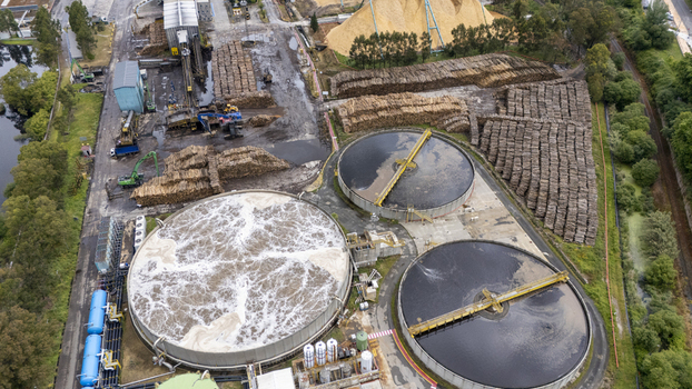 Aerial view of the Biofabrica de Ence industrial plant with large circular treatment tanks massive stacks of timber and machinery in Pontevedra Pontevedra Spain. Aerial view of the Biofabrica de Ence industrial plant with large circular treatment tanks massive stacks of timber and machinery in Pontevedra Pontevedra Spain.