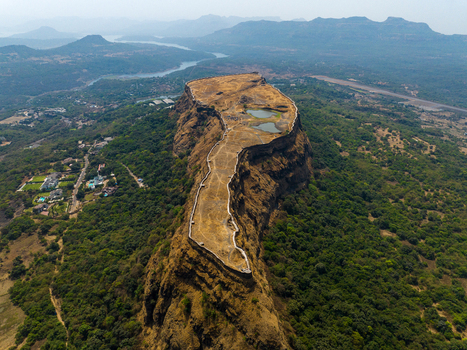 Aerial view of Korigad Fort featuring its historic stone fortifications plateau top with small ponds and surrounding lush green landscape in Peth Shahapur Maharashtra India. Aerial view of Korigad Fort featuring its historic stone fortifications plateau top with small ponds and surrounding lush green landscape in Peth Shahapur Maharashtra India.