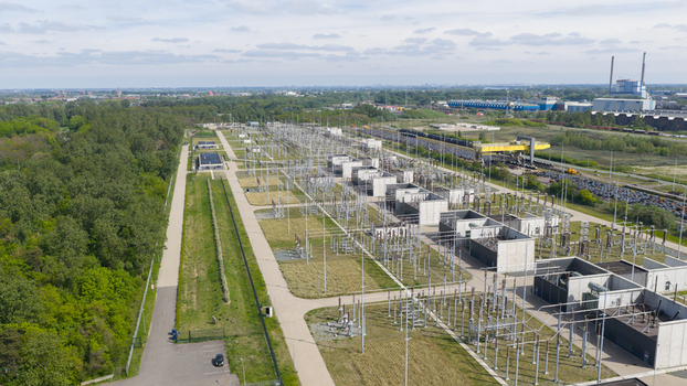 Aerial view of an electrical substation with high voltage power lines and industrial infrastructure surrounded by lush green trees Velsen Noord North Holland Netherlands.