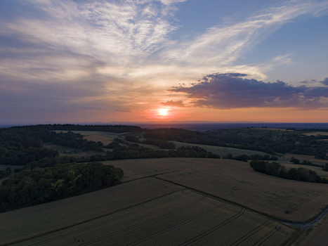 Aerial view of rolling agricultural fields and dense forests under a vibrant sunset sky in Weingarten Baden Wurttemberg Germany. Aerial view of rolling agricultural fields and dense forests under a vibrant sunset sky in Weingarten Baden Wurttemberg Germany.