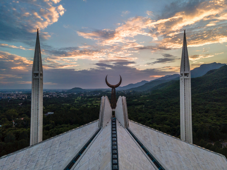 Aerial view of Faisal Masjid with its iconic minarets and crescent moon symbol overlooking the lush Margalla Hills under a dramatic sunset sky Islamabad Islamabad Capital Ter Pakistan. Aerial view of Faisal Masjid with its iconic minarets and crescent moon symbol overlooking the lush Margalla Hills under a dramatic sunset sky Islamabad Islamabad Capital Ter Pakistan.