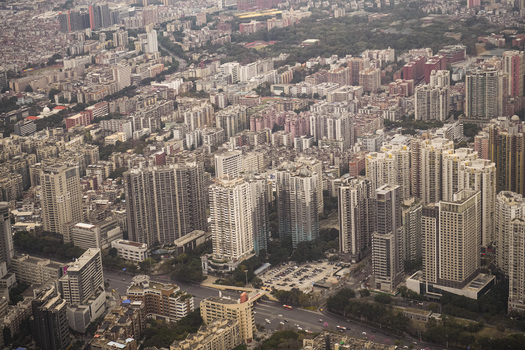 Aerial view of the dense urban landscape of Guangzhou featuring high rise residential buildings commercial towers and busy roads in Guangzhou Guangdong Province China. Aerial view of the dense urban landscape of Guangzhou featuring high rise residential buildings commercial towers and busy roads in Guangzhou Guangdong Province China.
