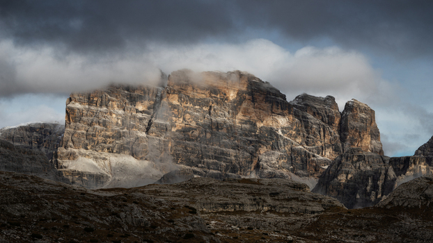 View of the rugged peaks of the Dolomites partially covered by dark clouds and dramatic light Trentino Alto Adige Italy. View of the rugged peaks of the Dolomites partially covered by dark clouds and dramatic light Trentino Alto Adige Italy.