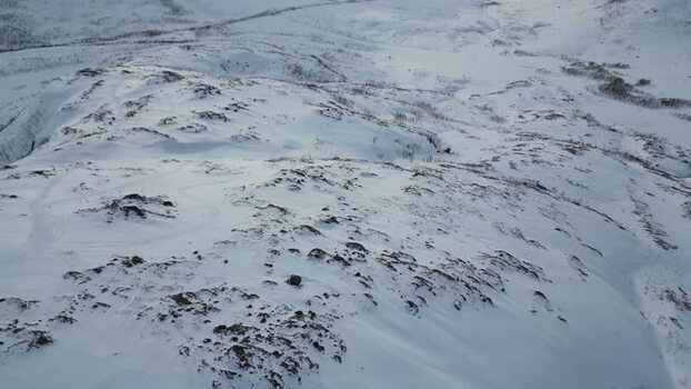 Aerial view of snowy Kvaloya mountain peaks in winter Norway.
