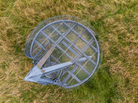 Aerial view of the metal structure of Uitkijktoren Hemelrijkse Waard contrasts sharply with the surrounding grassy field Oijen Noord Brabant Netherlands. Aerial view of the metal structure of Uitkijktoren Hemelrijkse Waard contrasts sharply with the surrounding grassy field Oijen Noord Brabant Netherlands.