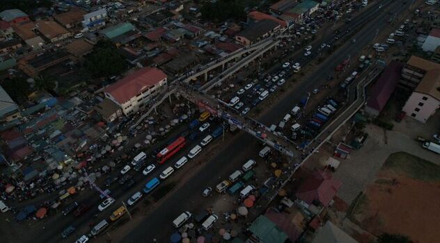 Aerial view of a busy road with heavy traffic a pedestrian footbridge and surrounding urban development in Ghana. Aerial view of a busy road with heavy traffic a pedestrian footbridge and surrounding urban development in Ghana.