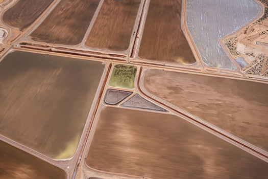 Aerial view of industrial salt mining ponds with geometric patterns varying shades of brown and grey mineral rich water and earthen embankments in Kalbarri Western Australia Australia. Aerial view of industrial salt mining ponds with geometric patterns varying shades of brown and grey mineral rich water and earthen embankments in Kalbarri Western Australia Australia.