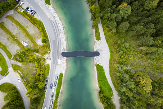 Aerial view of the bridge over the turquoise river with cars parked nearby nestled between verdant trees Plansee Tyrol Austria. Aerial view of the bridge over the turquoise river with cars parked nearby nestled between verdant trees Plansee Tyrol Austria.