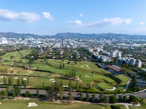 Aerial view of Wilshire Country Club with its lush green golf course sand bunkers and surrounding urban landscape in Los Angeles California United States. Aerial view of Wilshire Country Club with its lush green golf course sand bunkers and surrounding urban landscape in Los Angeles California United States.