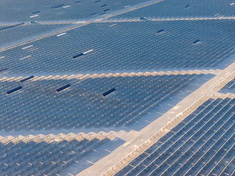Aerial view of a vast solar panel farm with rows of photovoltaic arrays casting long shadows across the desert landscape in Enterprise Nevada United States. Aerial view of a vast solar panel farm with rows of photovoltaic arrays casting long shadows across the desert landscape in Enterprise Nevada United States.