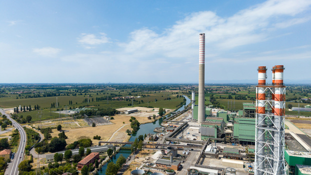 Aerial view of the Tavazzano con Villavesco power station with tall chimneys and industrial infrastructure near a canal in rural Tavazzano con Villavesco Lombardy Italy.