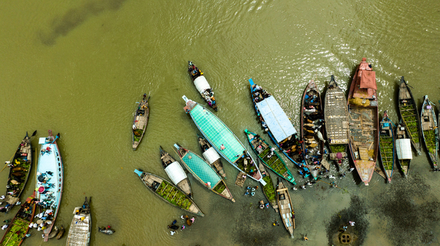 Aerial view of Baish Mowza Sarak Bazar with numerous wooden boats carrying produce and people on the river in Nabinagar Chittagong Division Bangladesh. Aerial view of Baish Mowza Sarak Bazar with numerous wooden boats carrying produce and people on the river in Nabinagar Chittagong Division Bangladesh.
