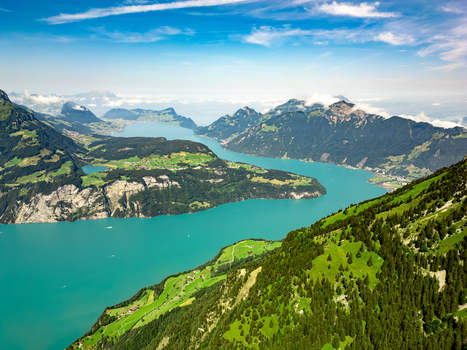 Aerial view of turquoise waters snake through verdant hills where shadows dance and clouds kiss the mountain peaks Vierwaldstättersee Switzerland. Aerial view of turquoise waters snake through verdant hills where shadows dance and clouds kiss the mountain peaks Vierwaldstättersee Switzerland.