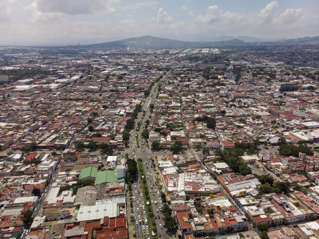 Aerial view of the Centro district in Guadalajara featuring dense urban architecture a main avenue with traffic and distant mountains Guadalajara Jalisco Mexico. Aerial view of the Centro district in Guadalajara featuring dense urban architecture a main avenue with traffic and distant mountains Guadalajara Jalisco Mexico.