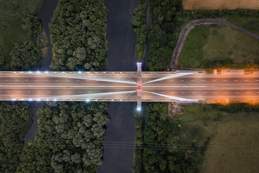 Aerial view of the Mary McAleese Boyne Valley Bridge crossing the River Boyne surrounded by dense green forests and fields at dusk Drogheda County Louth Ireland. Aerial view of the Mary McAleese Boyne Valley Bridge crossing the River Boyne surrounded by dense green forests and fields at dusk Drogheda County Louth Ireland.