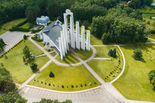 Aerial view of Elektrenai Church with modern white towers and geometric architecture surrounded by green lawns and pine forests in Elektrenai Vilnius County Lithuania. Aerial view of Elektrenai Church with modern white towers and geometric architecture surrounded by green lawns and pine forests in Elektrenai Vilnius County Lithuania.