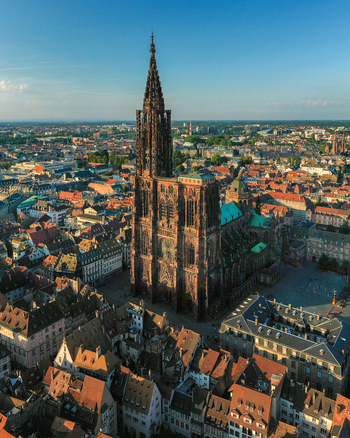Aerial view of Cathedrale Notre Dame de Strasbourg surrounded by historic rooftops and urban architecture in Strasbourg Grand Est France.