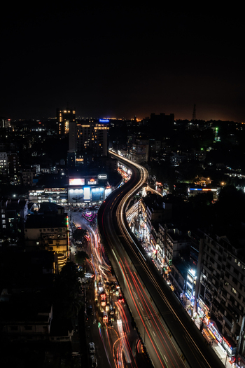 Chattogram Bangladesh 16 September 2023 Aerial view of the illuminated elevated expressway in Chattogram at night featuring long exposure light trails from moving vehicles and surrounding urban buildings.