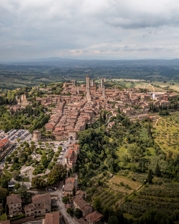 Aerial view of the historic town of San Gimignano with its iconic medieval towers terracotta rooftops and surrounding rolling hills in the Tuscan countryside San Gimignano Tuscany Italy. Aerial view of the historic town of San Gimignano with its iconic medieval towers terracotta rooftops and surrounding rolling hills in the Tuscan countryside San Gimignano Tuscany Italy.