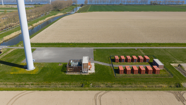 Aerial view of Energiepark Haringvliet Zuid with its wind turbine base substation and battery storage units amidst green fields Middelharnis South Holland Netherlands.