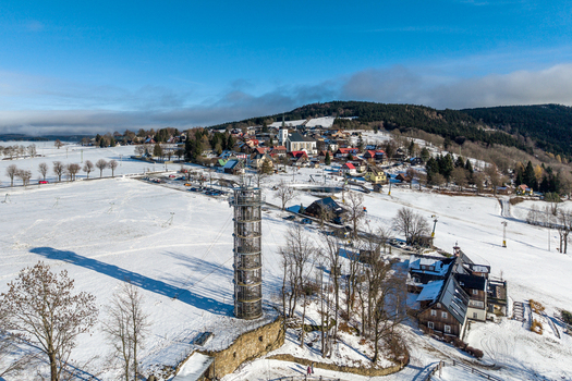 Aerial view of Majak Jary Cimrmana surrounded by snow covered fields and the village of Korenov in the Liberecky kraj Czechia. Aerial view of Majak Jary Cimrmana surrounded by snow covered fields and the village of Korenov in the Liberecky kraj Czechia.