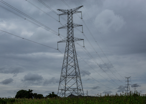 View of high voltage electricity transmission pylons standing in a rural field under a cloudy sky in Jos Plateau Nigeria. View of high voltage electricity transmission pylons standing in a rural field under a cloudy sky in Jos Plateau Nigeria.