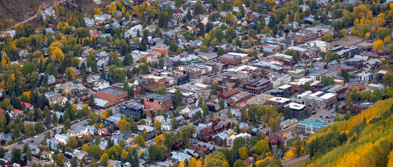 Aerial view of the historic town of Telluride nestled in a valley surrounded by vibrant autumn foliage and mountain scenery in Telluride Colorado United States.