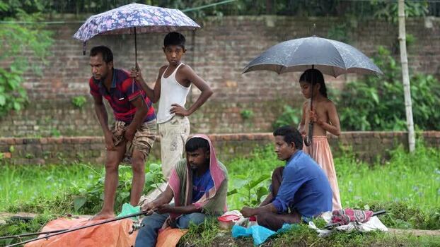 View of people fishing in the rain with umbrellas Bangladesh.