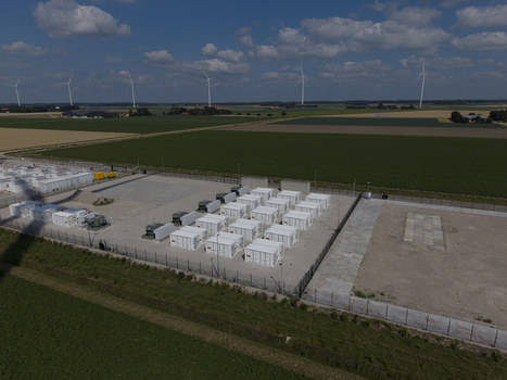 Aerial view of the Battery Energy Storage System at Wind Park featuring rows of white storage containers surrounded by a fence in the rural landscape of Dronten Flevoland Netherlands. Aerial view of the Battery Energy Storage System at Wind Park featuring rows of white storage containers surrounded by a fence in the rural landscape of Dronten Flevoland Netherlands.