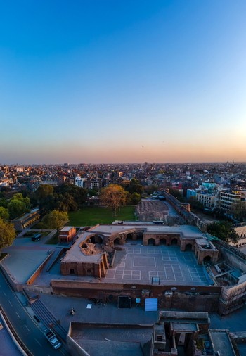Aerial view of Lahore Fort with its historic stone courtyards and Mughal architecture surrounded by the urban skyline of Lahore Punjab Pakistan.