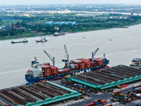 Aerial view of Chattogram Port with a container ship at the pier cranes loading cargo and shipping containers stacked in the terminal in Chittagong Chittagong Division Bangladesh.