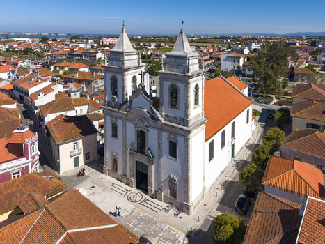 Aerial view of a grand white church with twin bell towers and a vibrant orange roof standing out in the sun Ilhavo Aveiro Portugal. Aerial view of a grand white church with twin bell towers and a vibrant orange roof standing out in the sun Ilhavo Aveiro Portugal.