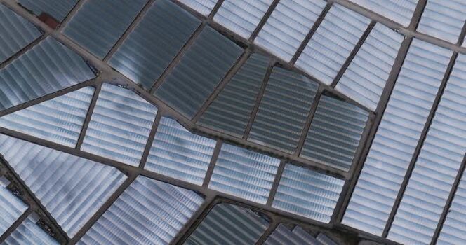 Aerial view of geometric greenhouse patterns Italy.