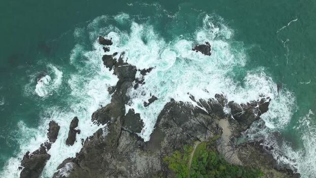 Aerial view of Siung Beach with waves crashing on rocks Indonesia.