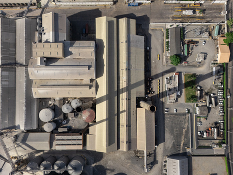 Aerial view of an industrial facility with large storage tanks factory buildings and parking areas in Bajos de Haina San Cristobal Provinc Dominican Republic.