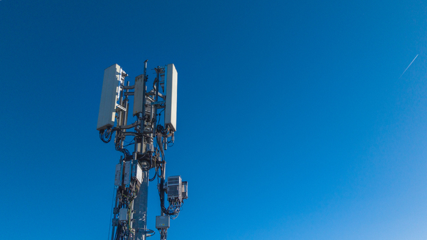 Aerial view of a phone mast with communication equipment and cables against a clear blue sky in Camberley England United Kingdom. Aerial view of a phone mast with communication equipment and cables against a clear blue sky in Camberley England United Kingdom.